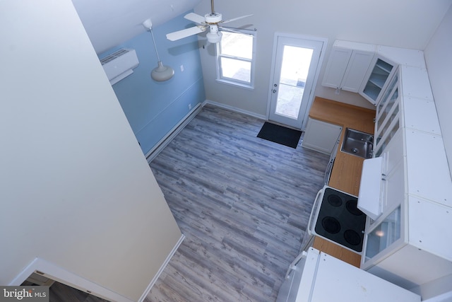 foyer entrance featuring ceiling fan, light hardwood / wood-style flooring, and lofted ceiling