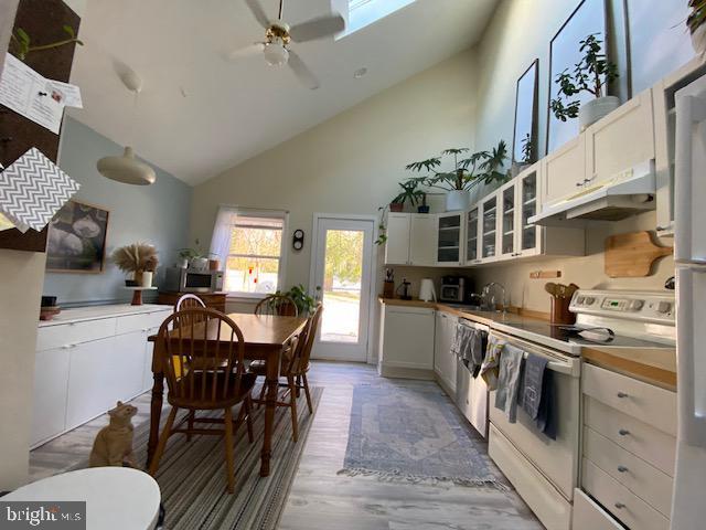 kitchen with ceiling fan, white electric range oven, light hardwood / wood-style flooring, high vaulted ceiling, and white cabinets