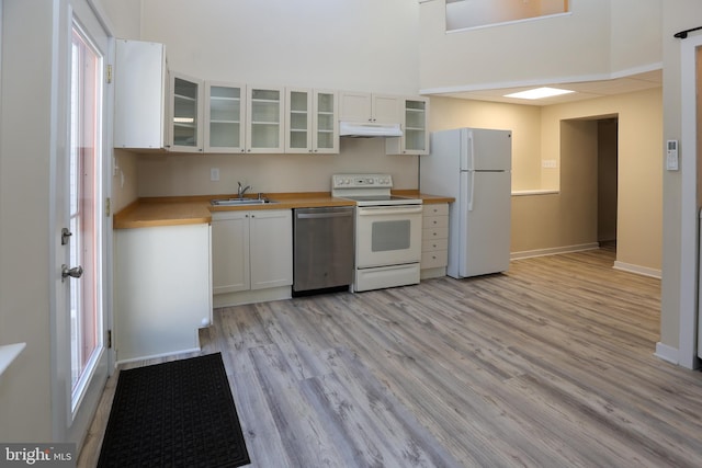 kitchen with white cabinets, white appliances, light hardwood / wood-style flooring, and sink