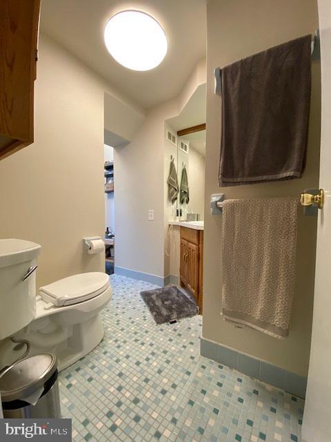 bathroom with tile patterned flooring, vanity, and toilet