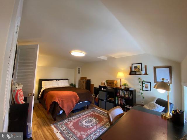 bedroom with vaulted ceiling and hardwood / wood-style flooring