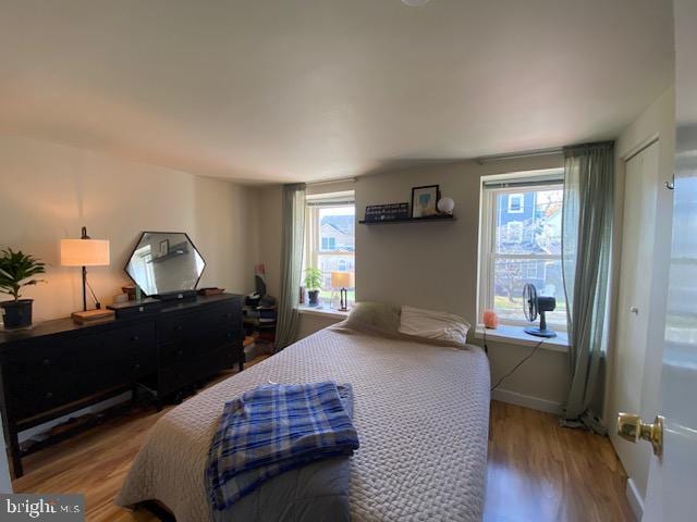 bedroom with wood-type flooring and multiple windows