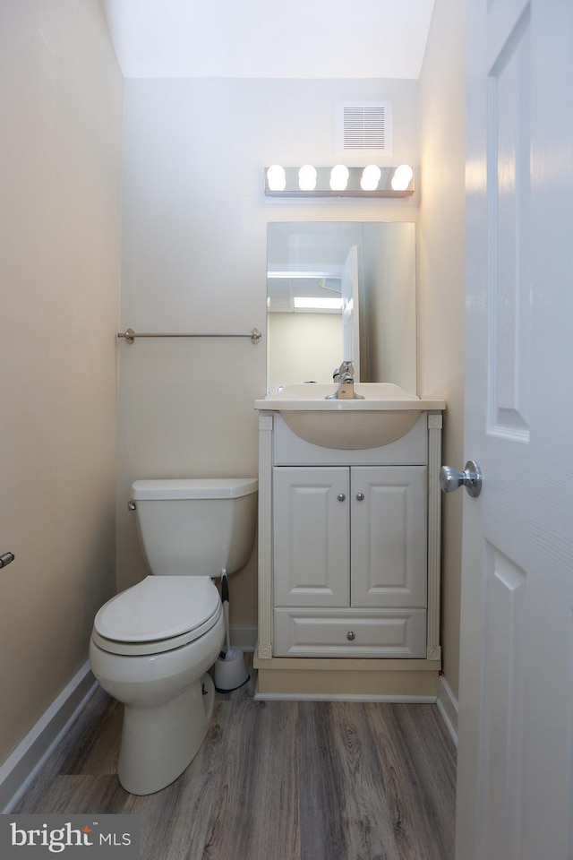 bathroom with vanity, hardwood / wood-style flooring, and toilet