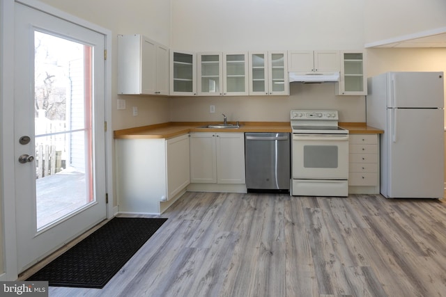 kitchen with white cabinetry, sink, and white appliances