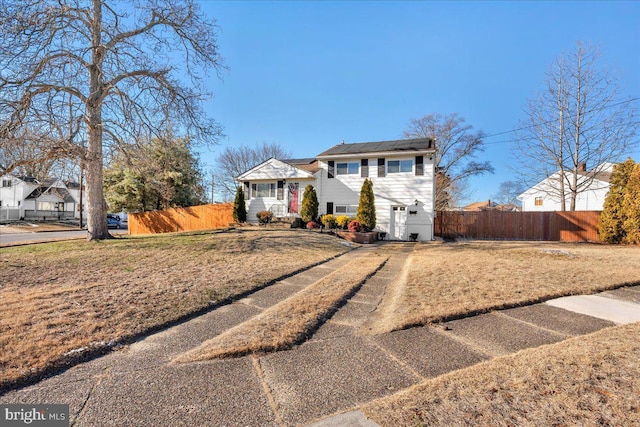 view of front of home with solar panels and a front lawn