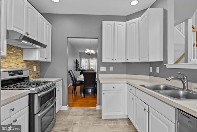 kitchen featuring hanging light fixtures, sink, white cabinets, and stainless steel appliances