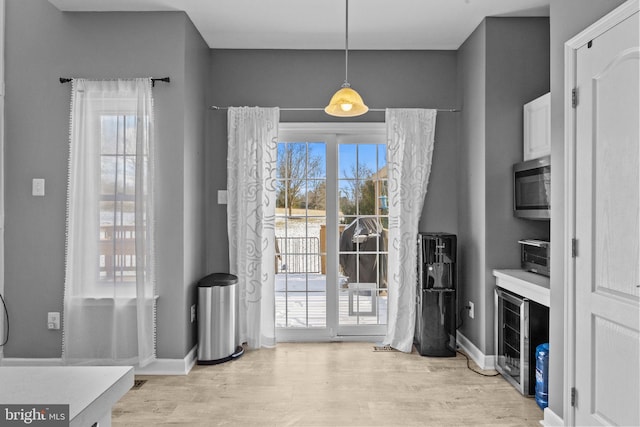 doorway to outside featuring wine cooler and light hardwood / wood-style floors