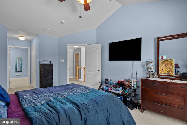 bedroom featuring ceiling fan, light colored carpet, lofted ceiling, and connected bathroom