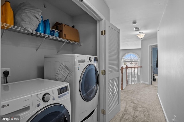 laundry area with washer and clothes dryer and light carpet