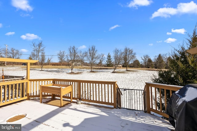 snow covered deck with a grill