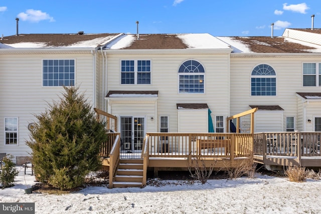 snow covered house with a wooden deck