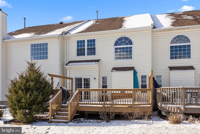 snow covered house featuring a wooden deck