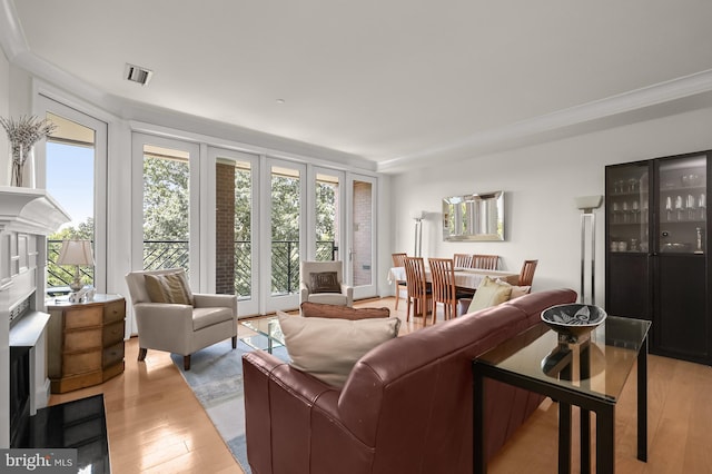 living room with light wood-type flooring and ornamental molding