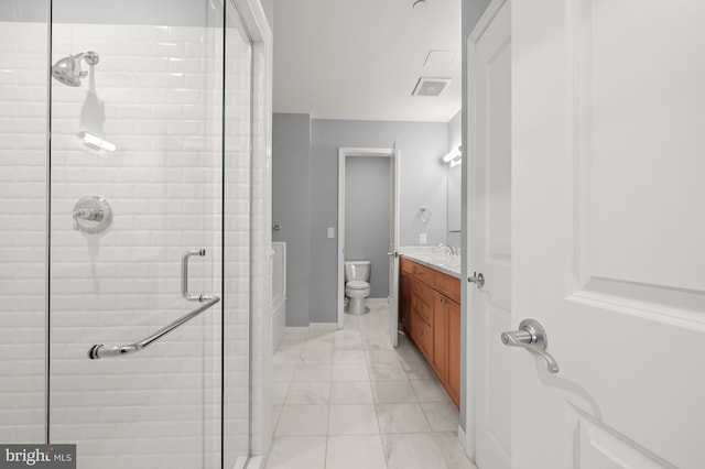 bathroom with an enclosed shower, vanity, and toilet