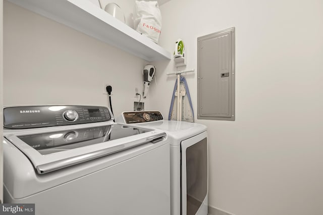 laundry room featuring electric panel and washing machine and clothes dryer