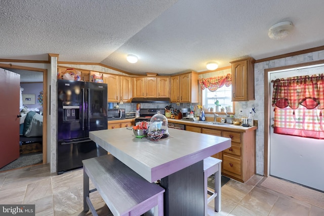 kitchen featuring a breakfast bar, lofted ceiling, sink, a center island, and black appliances