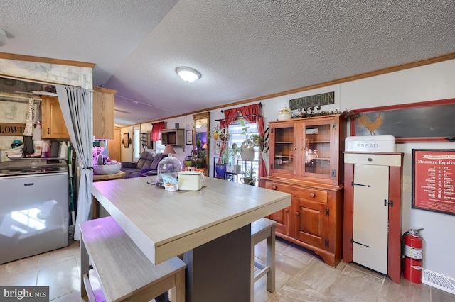 kitchen featuring crown molding, a kitchen bar, and a textured ceiling