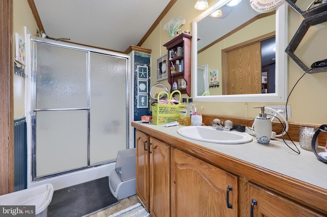 bathroom with vanity, lofted ceiling, an enclosed shower, and crown molding