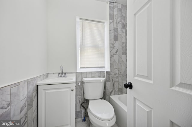 bathroom with vanity, tile walls, and toilet