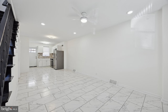 unfurnished living room with ceiling fan