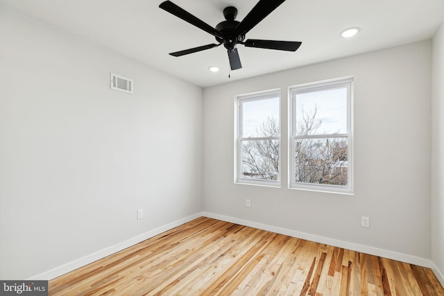 empty room with hardwood / wood-style floors and ceiling fan