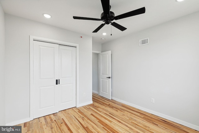 unfurnished bedroom with ceiling fan, a closet, and wood-type flooring