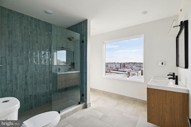 bathroom featuring tile patterned flooring, a tile shower, vanity, and toilet