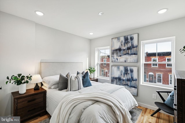 bedroom with light hardwood / wood-style flooring and multiple windows