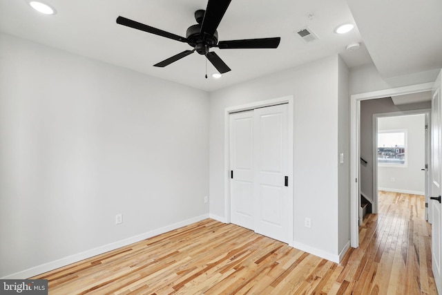 unfurnished bedroom with hardwood / wood-style flooring, ceiling fan, and a closet