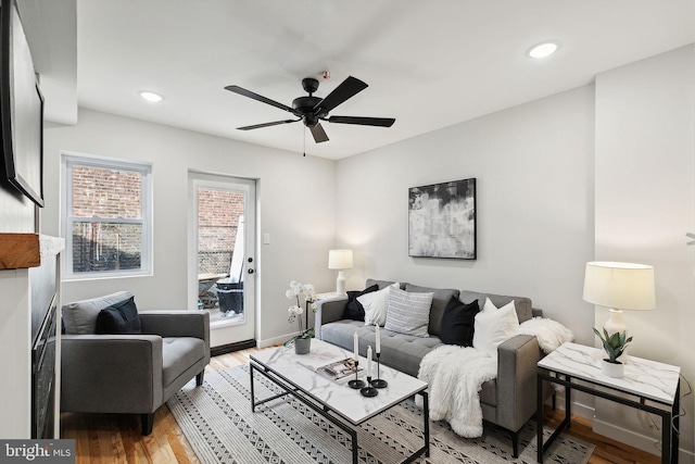 living room with ceiling fan and light wood-type flooring