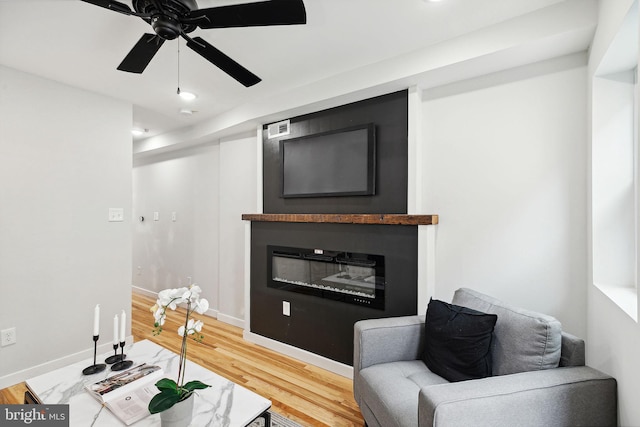 living room with ceiling fan and hardwood / wood-style flooring