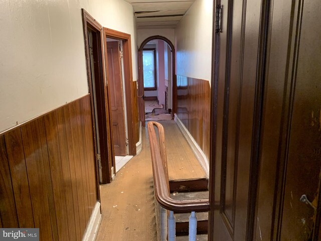 hallway featuring wood walls