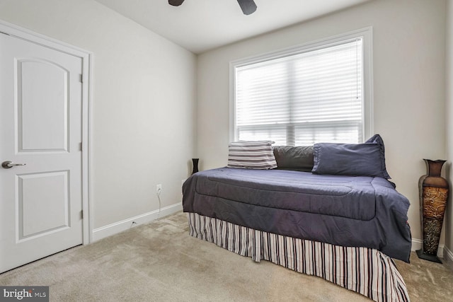 bedroom featuring multiple windows, light carpet, and ceiling fan