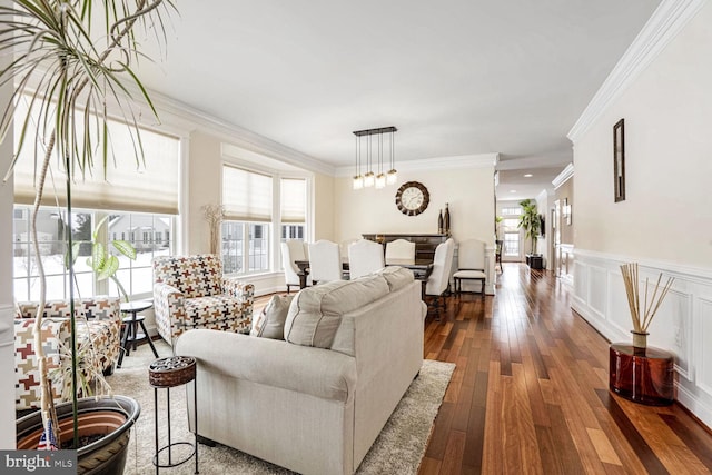 living room featuring a chandelier, dark hardwood / wood-style flooring, and ornamental molding