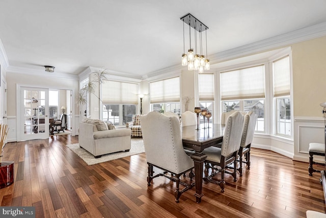 dining room featuring dark hardwood / wood-style floors, ornamental molding, and an inviting chandelier