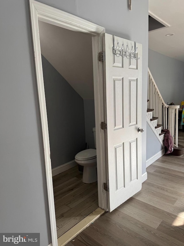 bathroom with toilet and wood-type flooring