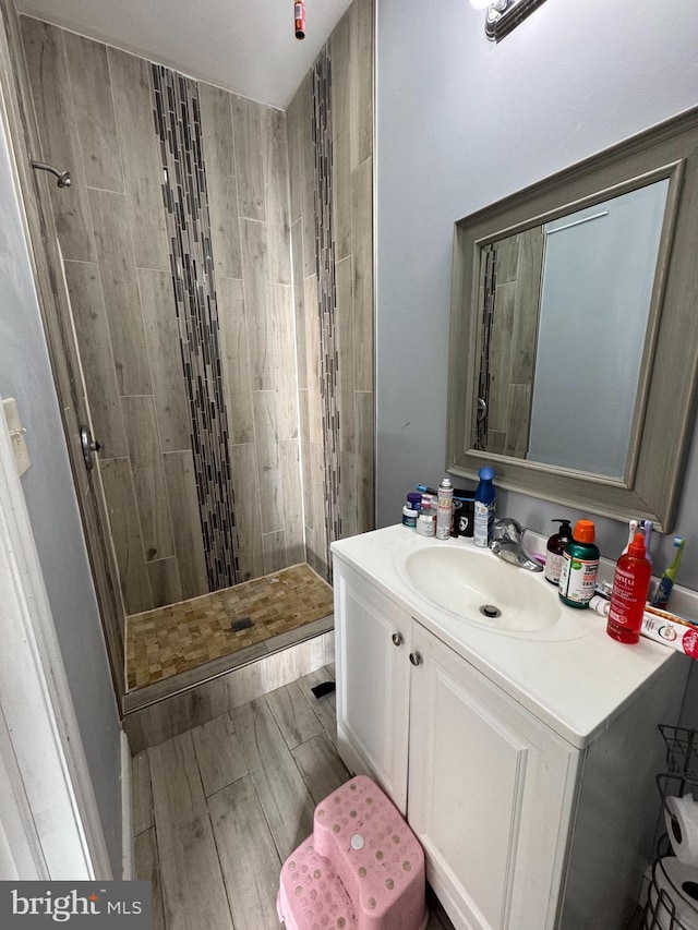 bathroom featuring vanity and tiled shower