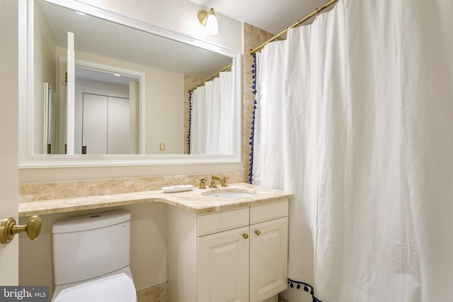 bathroom featuring curtained shower, vanity, and toilet