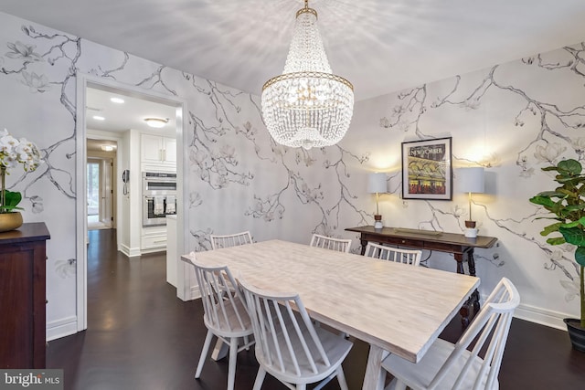 dining space with dark hardwood / wood-style flooring and an inviting chandelier