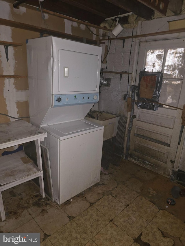 washroom featuring stacked washer / drying machine