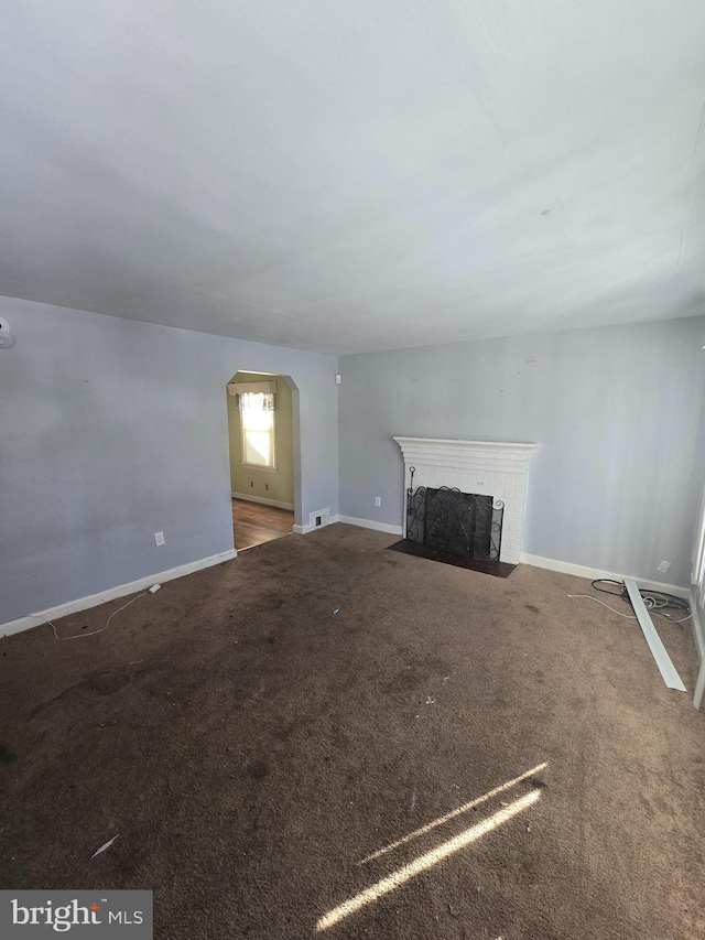 unfurnished living room featuring carpet and a fireplace