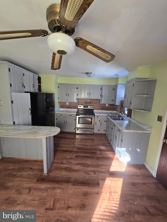 kitchen with black fridge, electric stove, sink, ceiling fan, and dark hardwood / wood-style flooring