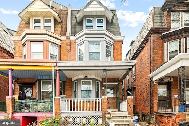 townhome / multi-family property featuring covered porch