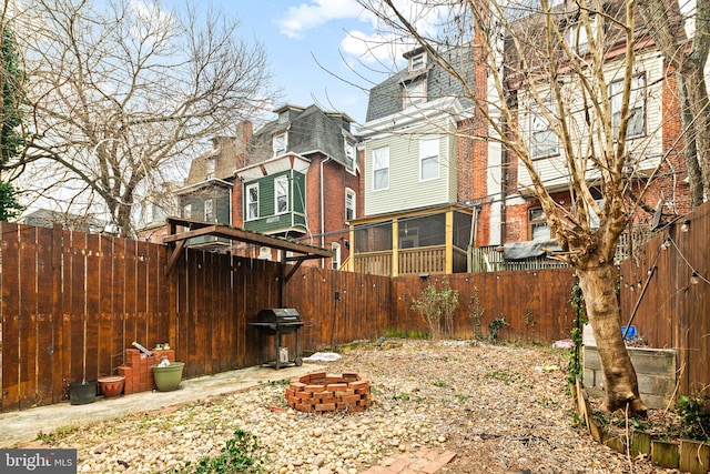 view of yard featuring a fire pit and a sunroom