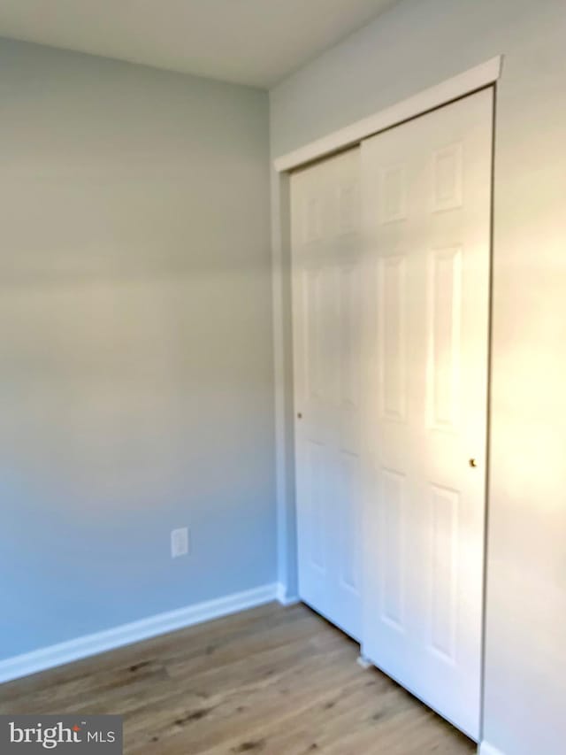 unfurnished bedroom with a closet and light hardwood / wood-style flooring