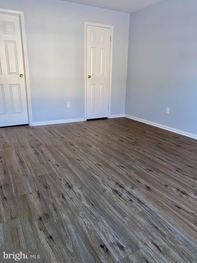 unfurnished room with dark wood-type flooring