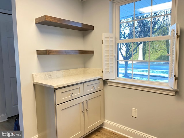 kitchen featuring hardwood / wood-style flooring, light stone countertops, and a wealth of natural light