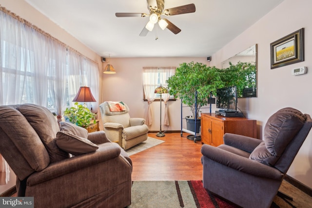 living room with ceiling fan and light hardwood / wood-style flooring