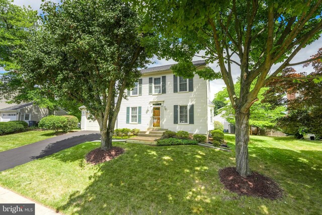 colonial-style house featuring a front lawn