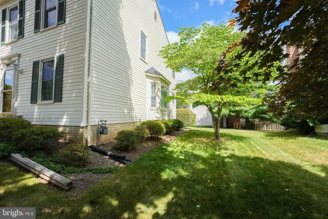 view of side of home with a yard